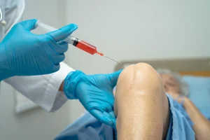 Pain specialist at Augusta Pain Center performing a minimally invasive knee injection to help reduce joint pain and inflammation.
